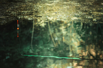 Fishing with a fishing rod and float. Selective focus. Tonal image.