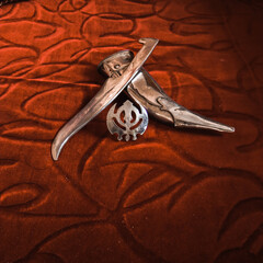 Knife with scabbard and khalsa monogram. The khalsa monogram is a prestigious symbol in Sikh...