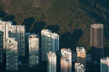 Aerial View of Apartment Buildings With Sunlight on Top of Them and a Hill Behind