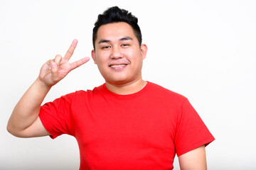 Portrait of happy young handsome overweight Asian man