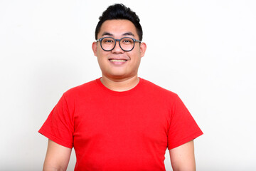 Portrait of happy young handsome overweight Asian man - 368297744