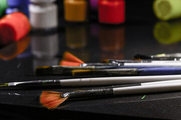 Multicolored Paint Bottles with Painting Brushes, Selective focus, selective focus on subject.