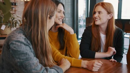 Group of young friends sitting and talking at a cafe. Young women meeting in a coffee shop and chatting.
 - Powered by Adobe