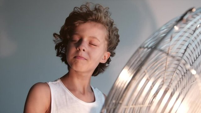 Boy holding a running fan while screaming