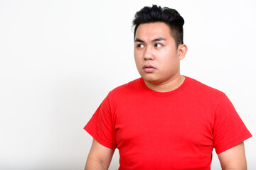 Obraz premium Portrait of stressed young overweight Asian man looking away