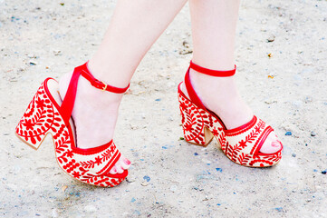 Woman likes to walk in her red high heeled funky fashion shoes.