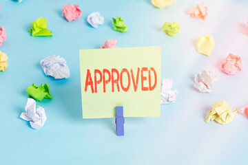 Word writing text Approved. Business photo showcasing to have or express a favorable opinion of, to accept as satisfactory Colored crumpled papers empty reminder blue floor background clothespin