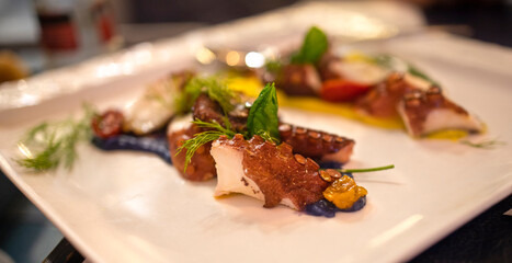 Selective focus on the octopus salad plate. Concept of Mediterranean cuisine, healthy and tasty