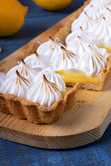 Obraz na płótnie Canvas Lemon tart with caramelized meringue on the blue wooden table 