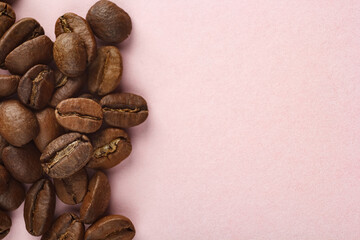 Coffee beans laid out on a pink background