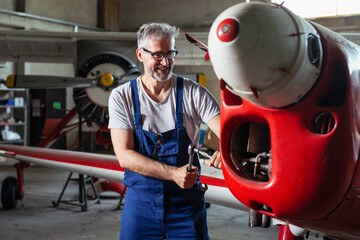 Senior engineer repairing aircraft engine