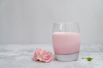 glass of  pink milk with pink flowers.