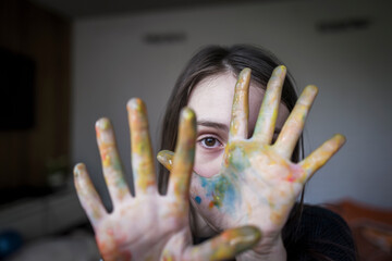 Close up portrait girl with finger paint covering hands