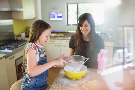 Mother and daughter baking in kitchen