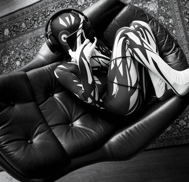 Boy in alien costume using smart phone in armchair