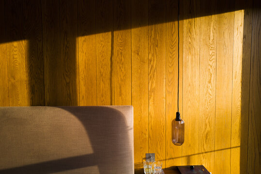 Sunlight over wood paneling in bedroom