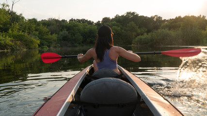 
the girl floats on a kayak on the river.