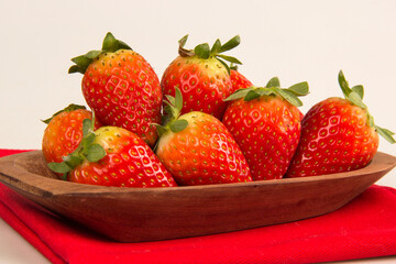Red fresh strawberry in a bowl on white background.