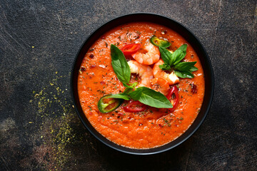 Delicious cold tomato soup or gazpacho with shrimps. Top view with copy space.