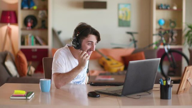 The guy looks at the computer and laughs