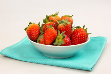 Red fresh strawberry in a bowl on white background.