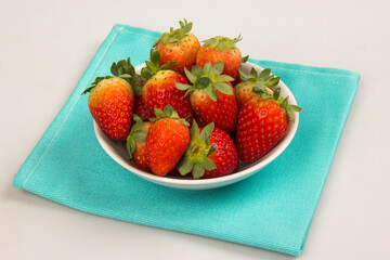 Red fresh strawberry in a bowl on white background.