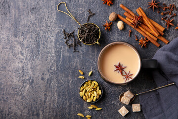 Indian masala tea with milk and spices in mug. Grey background. Copy space. Top view.