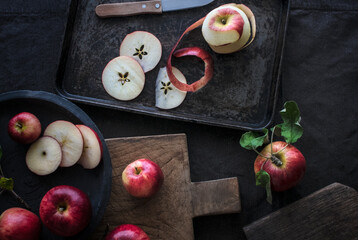 Fresh red apple slices on cutting board and sheet pan