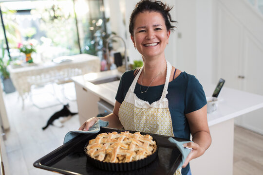 Portrait proud woman with baked lattice pie in kitchen
