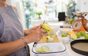 Close up woman slicing green apples for pie in kitchen