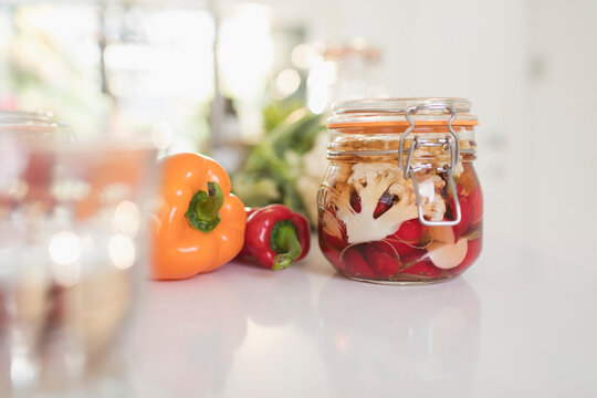 Close up preserved vegetables in jars on kitchen counter