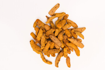 Dried Turmeric Roots as a whole on white background, selective focus