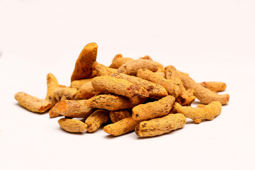 Dried Turmeric Roots as a whole on white background, selective focus
