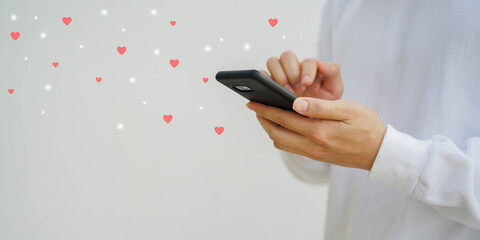 close up man hand touch screen on mobile phone to rating score of service satisfaction by send many heart shape for social media marketing and business responsibility concept