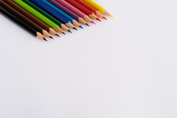 Colored sharpened pencils at the top on a white sheet of paper