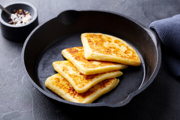 Traditional Scottish tattie potato scones in cast iron pan. Dark background. Close up.