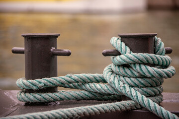 Nautical tie downs secure moored boats on a wharf pier.