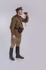 Male actor in the uniform of a Soviet Army officer during World War II with binoculars in his hands
