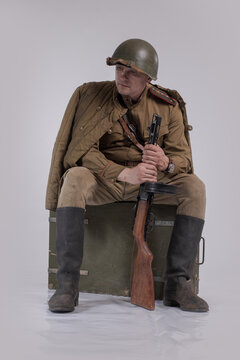 Male actor in the uniform of an officer and a helmet of the Soviet Army during World War II with a rifle in his hands
