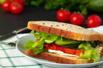Healthy sandwich with vegetables on dark wooden background