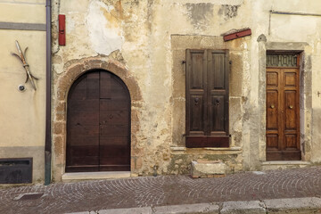 Fototapeta na wymiar Wooden doors on the facade to the ancient medieval city of Leonessa, Lazio region, Rieti province, Italy