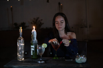 Young woman drinking a cocktail in a bar