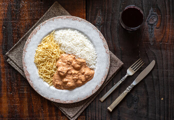 Chicken stroganoff with rice and french fries.