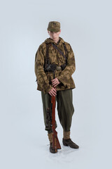 Male actor in protective camouflage of a sniper, military uniform of a soldier of the German army...