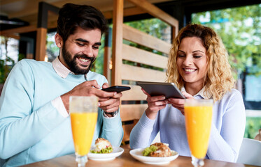 Young couple sitting in a cafe, having breakfast. Love, dating, food, lifestyle concept