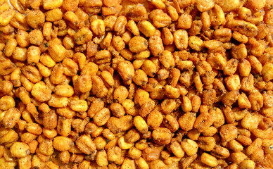 Background made of roasted salted spicy corn. Snack and food. Top view. Roasted corn nuts.