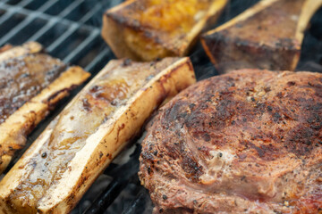manos preparando distintos cortes en el asador y parrilla. tomahwk , rib eye , new york  tuetatons  con sal y mienta 