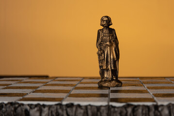 stylized chess pieces ( Bishop ) on a board with orange background and selective focus