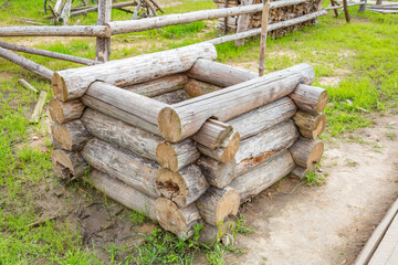 Old wooden well made of dry logs in the countryside