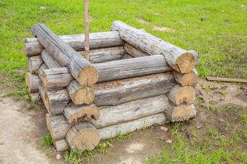 Old wooden well made of dry logs in the countryside